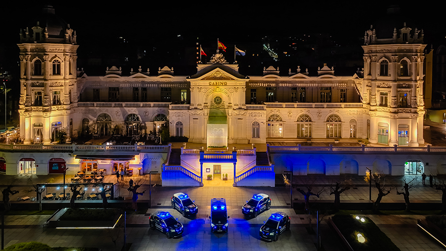 Coches de la Policía Nacional frente a edificio histórico iluminado de Santander.